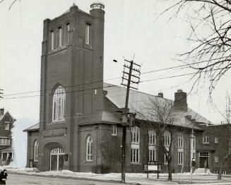 Exterior of brick church with prominent belfry tower above front entrance.