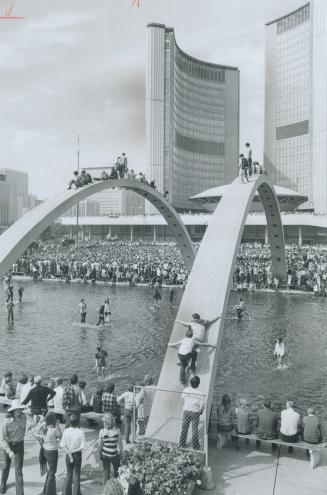 Riding High on Rocks. City Hall square was so jammed yesterday afternoon that younsters took to climbing over the pool as Toronto's Lighthouse rock gr(...)