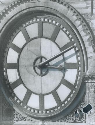 This clock has an extra face, Metro Property Department worker George Thompson (arrow) peers from the clock tower of old city hall