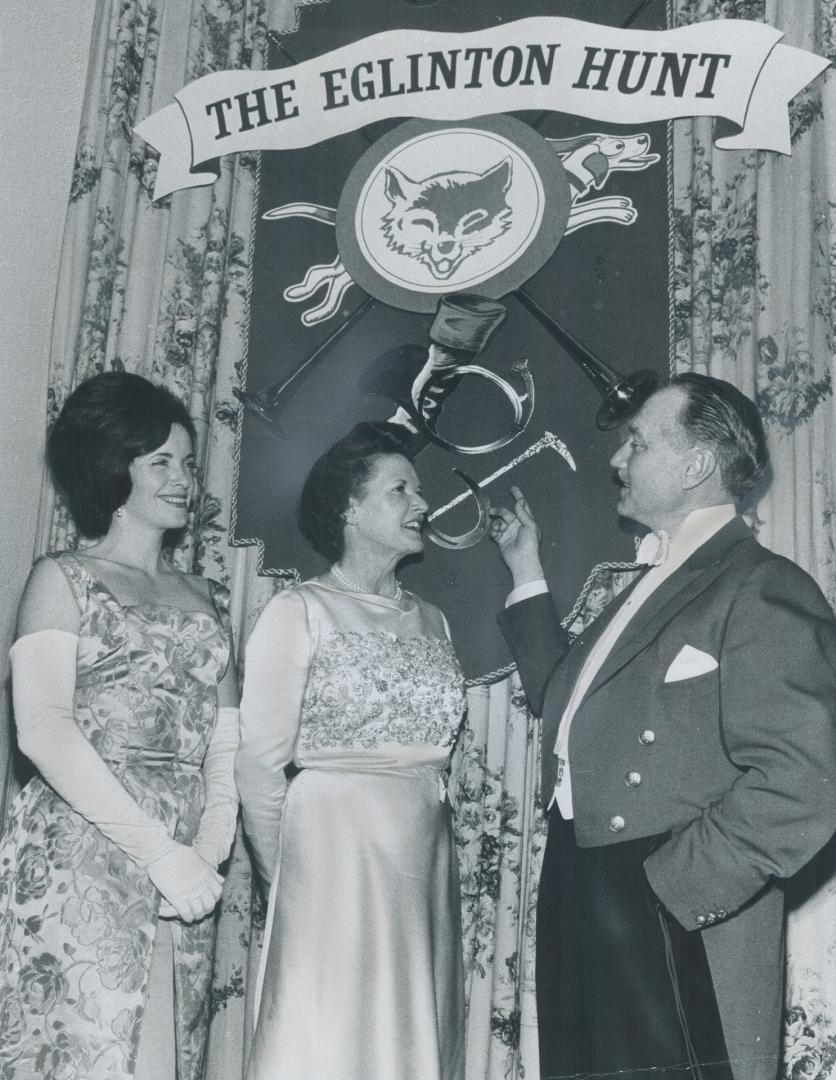 Lt. Col. G. Allan Burton, joint master of the Eglinton Hunt, shows off the glamorous decorations at the ball at the Toronto Hunt Club last night. Admi(...)