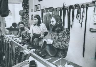 Leather shop in Baldwin St. commune, one of the oldest in Toronto, keeps Phil Mullins, left, Mary Rauton and Steve Burdick busy. Sale of the leather g(...)