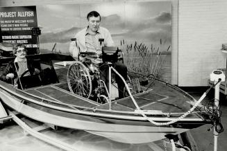 Wheelchair fisherman: Bill White, 46, a handicapped New Brunswick fisherman, demonstrates the boat he designed for use by the handicapped