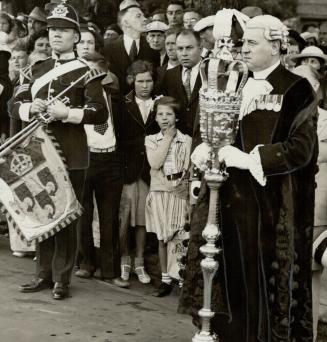 The mace-bearer stands in (3) before a crowd of onlookers