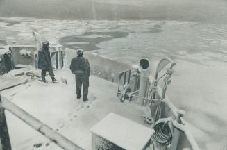 Approaching Icefield floating in the centre of Toronto harbor, first mate Ralph Lacey and deckhand Bill Dubeau watch the progress of the Island ferry (...)