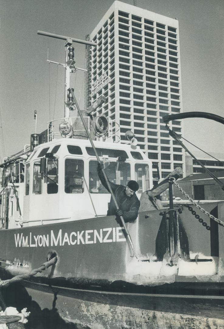 Fireman with a cold job, Noel Clarke chips away the ice from the bow of the fireboat Wm