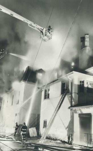Raging blaze, Toronto firefighters on aerial ladders battle a spectacular fire that gutted a three-storey vacant house near the corner of Jarvis and D(...)