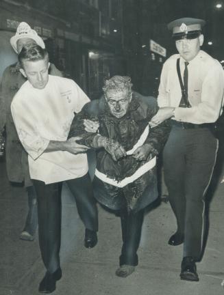 Prize-winning photo, by Star photographer Frank Lennon, in Toronto Firefighters' Association competition shows injured fireman Capt. Les Burlie helped(...)