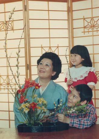 Japanese festival welcomes signs of spring, Kyoko Abe shows the art of Ikebana, or Japanese flower arranging, to Johnny Iwashita, 8 and Catherine Oikawa, 5