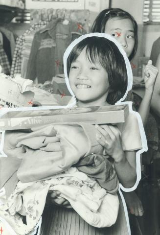 Horrors of fleeing Viet Nam fade as Hang Thi Nguyen, 8, receives clothing at Ontario Welcome House