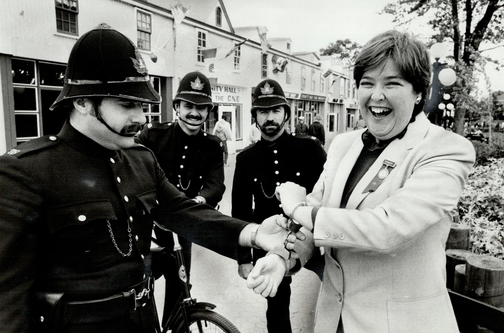 Bobbles catch archivist: Patrolling the CNE's Centennial Square, Tony Altomare puts the handcuffs on Ex archivist Nancy Hum, but it's all in fun