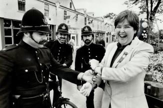 Bobbles catch archivist: Patrolling the CNE's Centennial Square, Tony Altomare puts the handcuffs on Ex archivist Nancy Hum, but it's all in fun