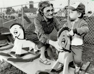 Ride 'em cowboy: Dorothy Mitchell, who runs the CNE's lost children department, plays with a young boy while waiting for his parents to arrive