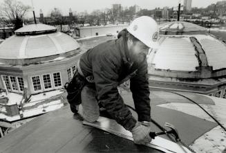 Fixing a crown, Roofer Steve Long works on the east pavillion of the Music Building at Exhibition Place yesterday