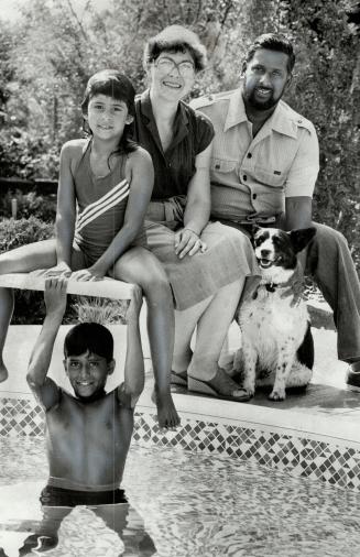 Relaxing at home: Howard and Kathy Sammy and their daughter Joy, 7, sit by the pool as son Julian, 10, cools off in the water