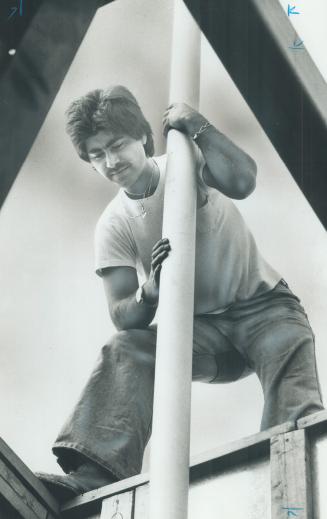 Image shows a man putting a flagpole in place.