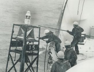 Image shows some crewmen of the icebreaker working in the storm.