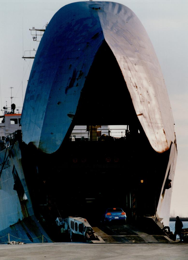 Image shows cars entering a huge ship.