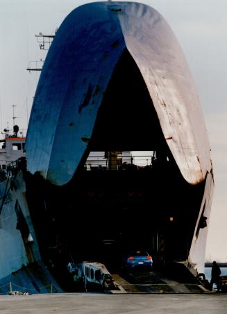 Image shows cars entering a huge ship.