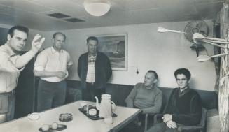 Image shows five crew members playing darts.