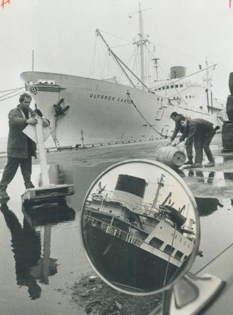 Image shows dock workers unloading the cargo ship.