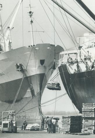 Image shows a few people looking at the ships loading in progress.