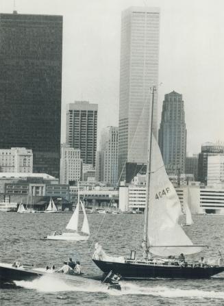 Image shows a number of boats on the lake with the Harbour buildings in the background.