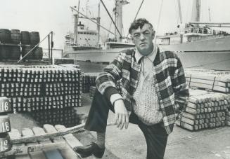 Image shows a worker standing in the ship loading area.