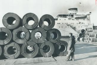Image shows some cargo items at the Harbour with a ship in the background.