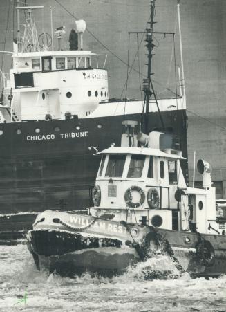 Image shows a smaller boat "William Rest" with a big ship "Chicago Tribune" in the background.