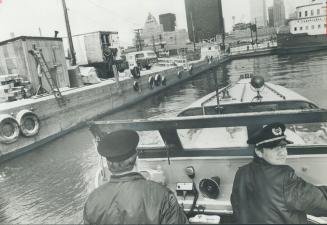 Image shows two police officers on the boats returning to the port.