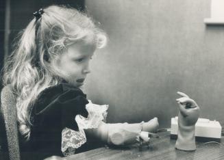 Before being fitted for her new myoelectric hand, three-year-old Rose Newhouse practises making it open and close by flexing the proper muscles in her forearm