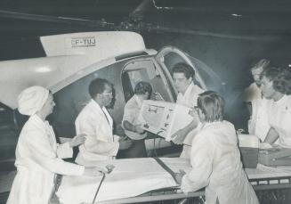 The first emergency case to use the new heliport atop the Hospital for Sick Children is carried from the helicopter to a stretcher manned by an emerge(...)