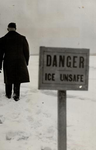 Image shows a gentleman walking on the snow covered lake. There is a sign that reads: Danger. I ...