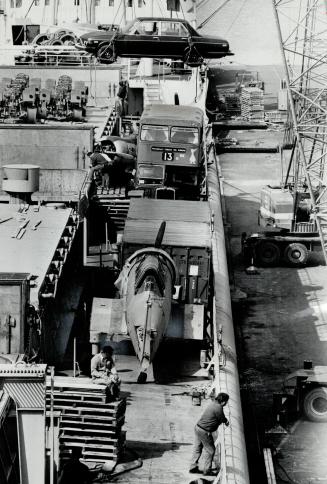 Image shows a cargo ship deck loaded with buses, cars and other goods.