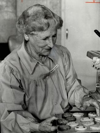 Mrs. Thomas cartmell makes another batch of her good cookies. Every week the 80-year-old woman takes basket of goodies to old folks in hospital