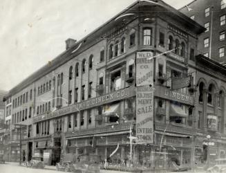 Corner view of four-storey brick building with sign on corner of façade reading, W. &amp; D. Di ...