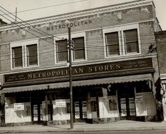 Two-storey brick building; sign above window awning reads, Stores from Coast to Coast, Metropol ...