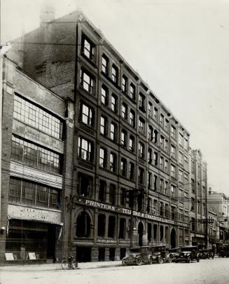 Exterior view of six-storey brick building with sign reading, Printers - Telford &amp; Craddock…