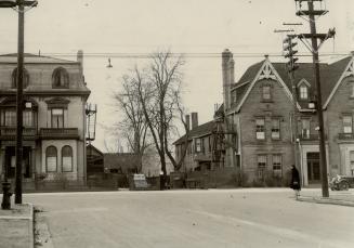 Street view showing two three-storey brick houses at intersection; house on left has Mansard ro ...