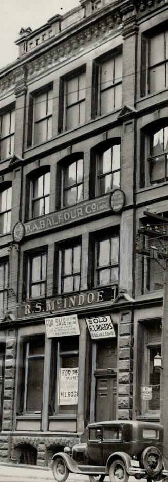 Façade of four-storey stone building. Sign above second floor window reads, D.A. Balfour Ltd. S…