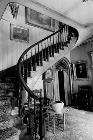 A winding staircase leads from cavern-like front hallway to bedrooms upstairs