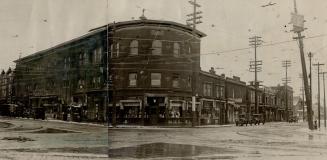 Street view of three-storey brick building at intersection with curved front. Left, sign overha ...