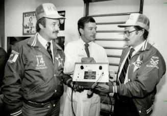 Pitching in for sick children. Members of the Toronto Star's softball club, Glenn Middleton, left, and Bert Dandy, right, present ultrasound machine t(...)