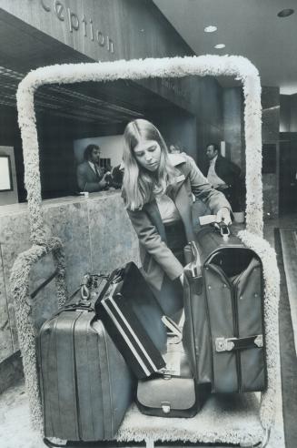 Bellhop Janet Scott, 20, loads luggage on a cart at the Harbour Castle Hotel