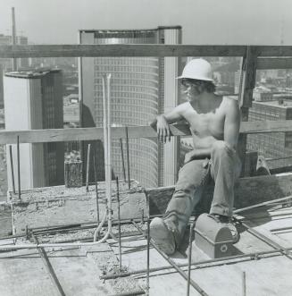Getting an over-all view of City Hall, Sven Miglin, 17, a carpenter's helper, eats lunch in the sun on the 31st floor of the Sheraton Four Seasons hot(...)