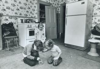 Water overflowing upstairs made the hole in the ceiling 6-year-old Donald Moore points to while his little brother, Stephen, 5, plays on the cockroach(...)