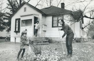On Algonquin island, Irvin and Myriam Waller and daughter Ginie, 5, tidy the yard in front of their house, which will be razed if Metro Council votes