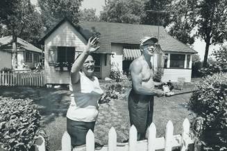 Pausing in their gardening, Mr. and Mrs. Bob Milthorpe wave at Island visitors outside their home at 16 Lakeshore Ave., Ward's Island. 