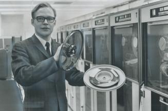 Franz Robinow, systems analyst at the Toronto public library, Displays labor-saving tape