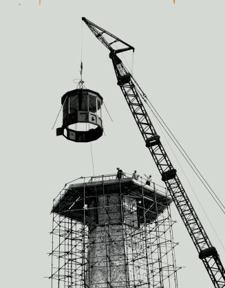 Lowering away. A 5,000-pound cast metal light dome is lowered into place atop the Centre Island lighthouse built in 1808 and now being restored as a historic landmark